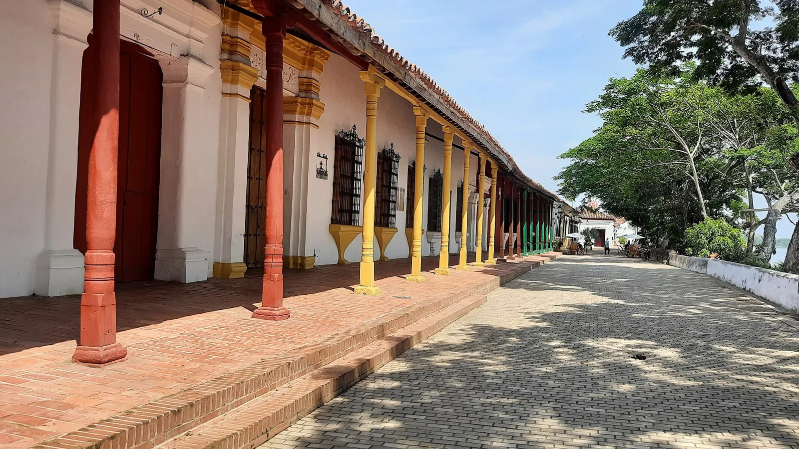 Calçada da Albarrada em Mompox, com casas coloniais de portais e colunas coloridas ao longo da margem do rio Magdalena