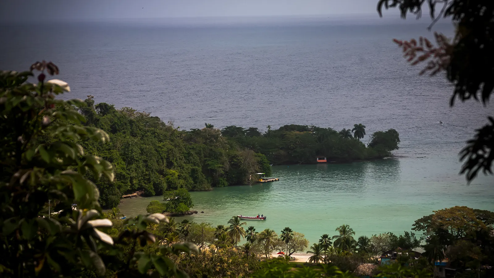 Bahía Aguacate, perto de Capurganá, com água verde-clara, mata densa e casas na encosta