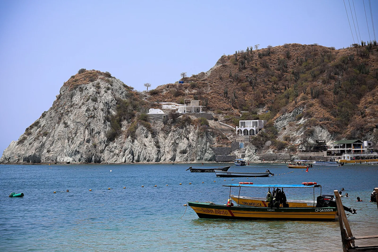 Baía de Taganga, perto de Santa Marta, com lanchas de passeio e morro rochoso à beira do mar