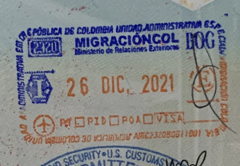 Carimbo de saída da Migración Colombia no aeroporto de Bogotá (BOG), datado de 26 de dezembro de 2021, numa página de passaporte