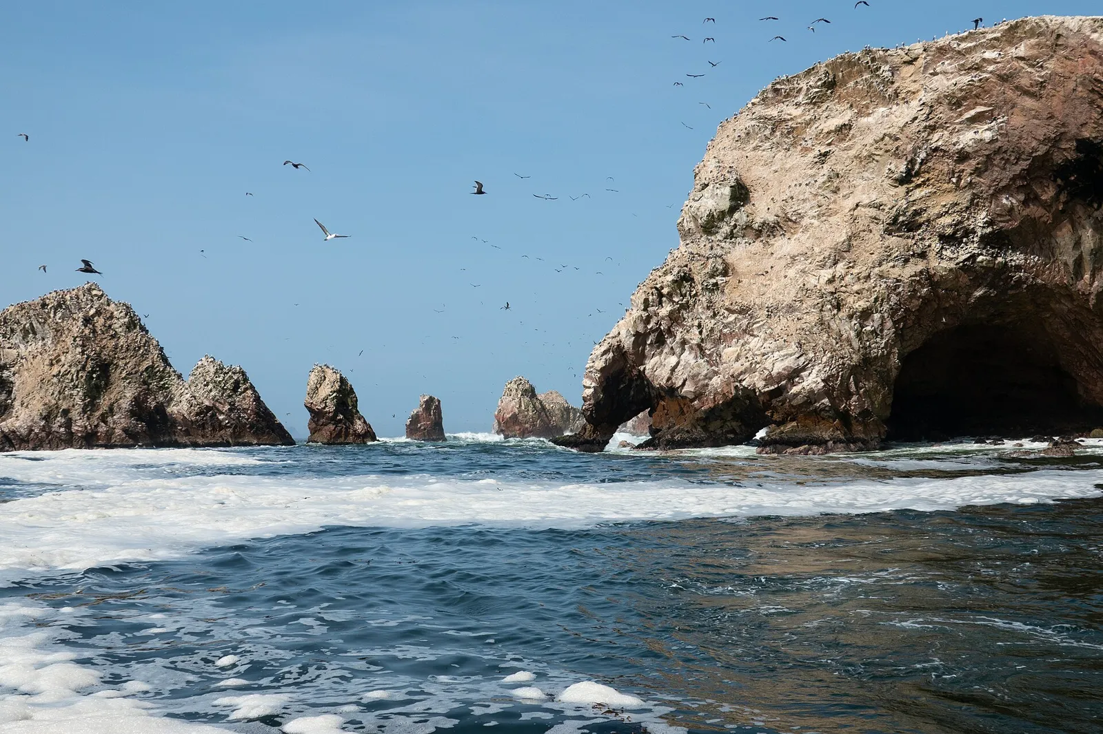 Formações rochosas com arcos sobre o mar nas Islas Ballestas, visitadas de barco a partir de Paracas, no Peru