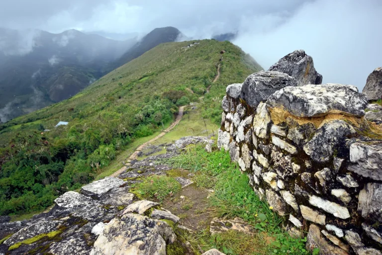 Muralha de pedra calcária de Kuélap no alto da montanha, com o vale do Utcubamba e nuvens ao fundo, Amazonas, Peru
