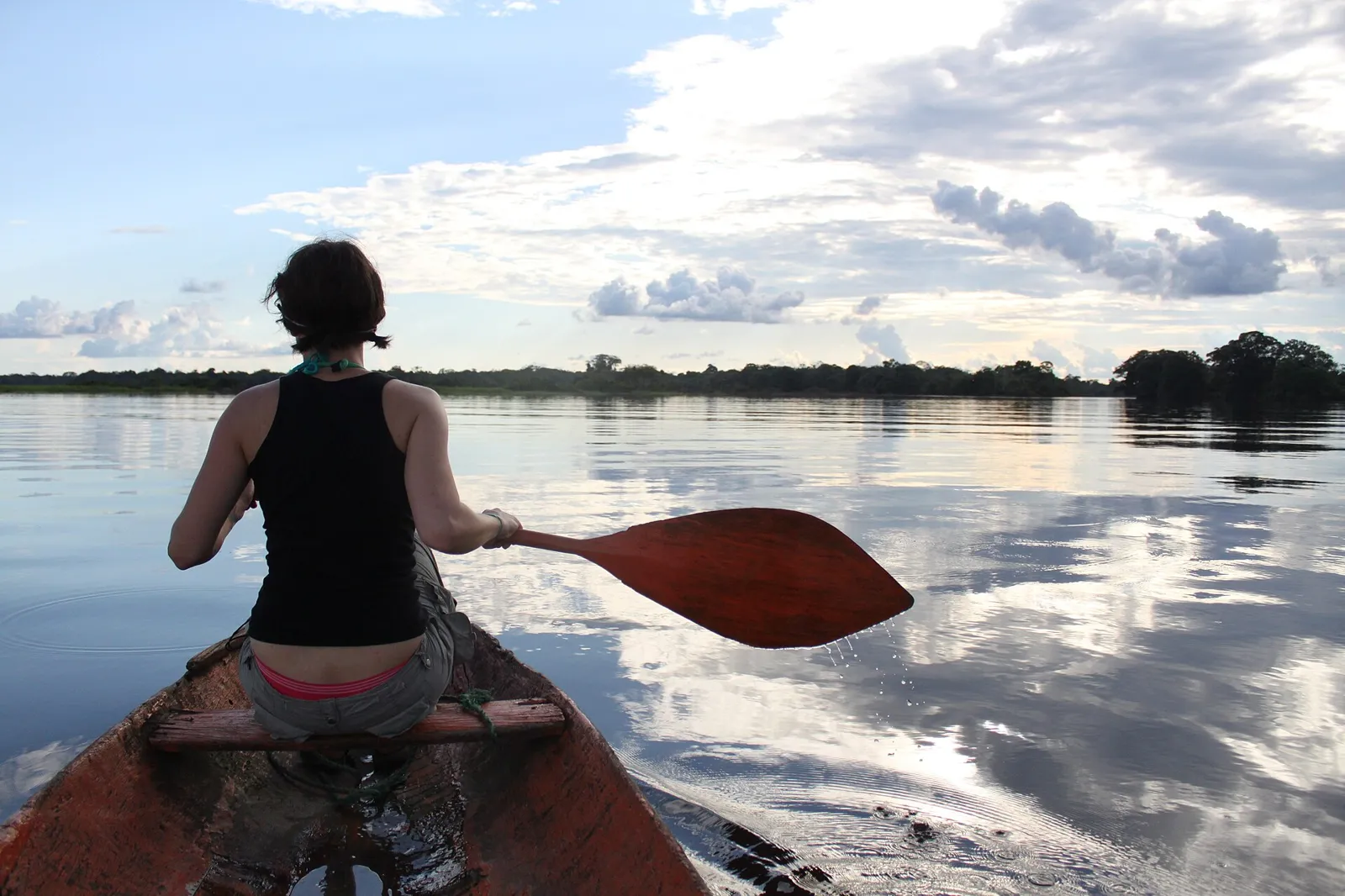 Pessoa remando em canoa de madeira no Lago Tarapoto, perto de Puerto Nariño, no Amazonas colombiano
