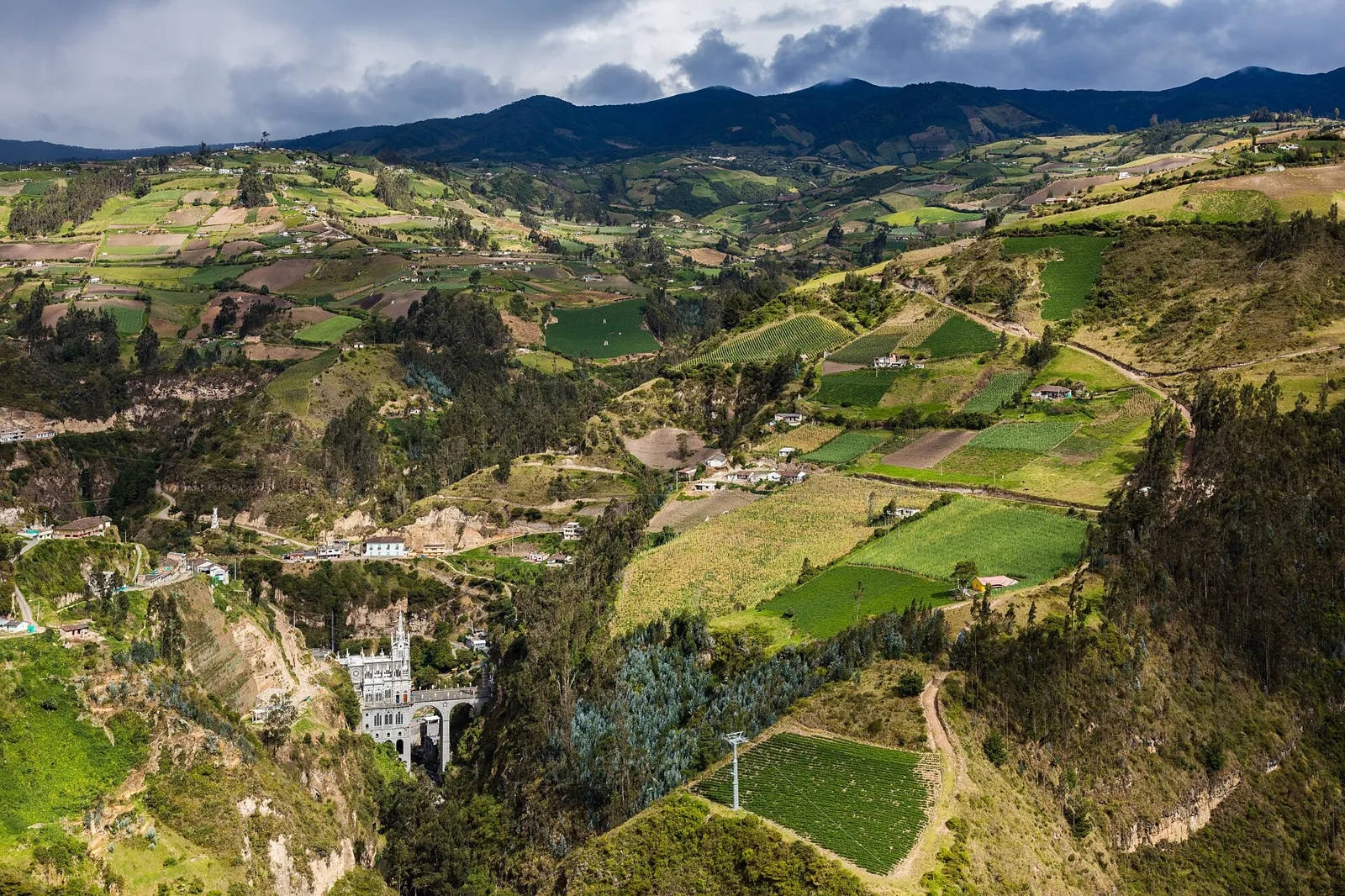 Vista do alto do cânion do Guáitara com o Santuário de Las Lajas ao fundo e lavouras em mosaico nas encostas de Ipiales