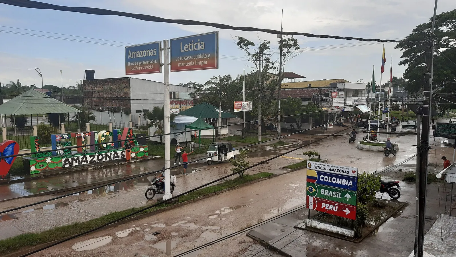 Avenida na fronteira entre Leticia, na Colômbia, e Tabatinga, no Brasil, com placas indicando Colômbia, Brasil e Peru