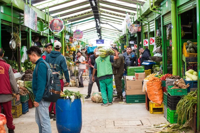 Corredor do mercado de Paloquemao, em Bogotá, com bancas de frutas, verduras e legumes