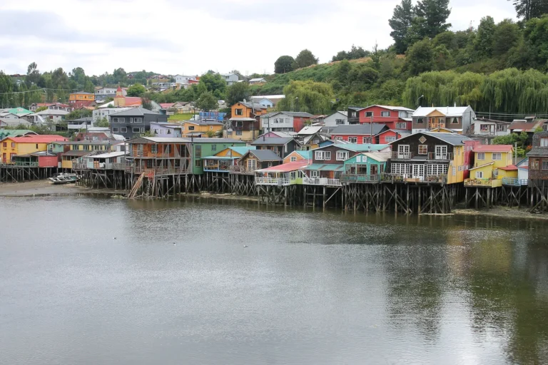 Palafitos coloridos de Castro, em Chiloé, casas de madeira sobre estacas à beira do fiorde com a maré alta