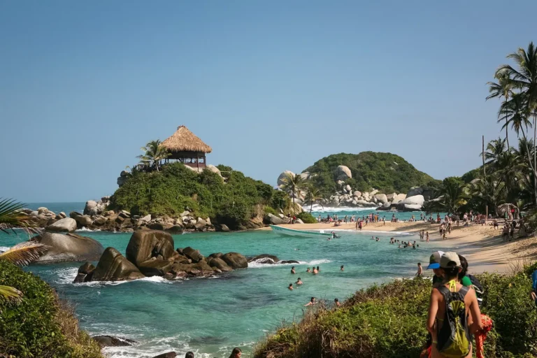 Praia de Cabo San Juan del Guía, no Parque Tayrona, com água turquesa, pedras de granito e o mirante de palha sobre o morro