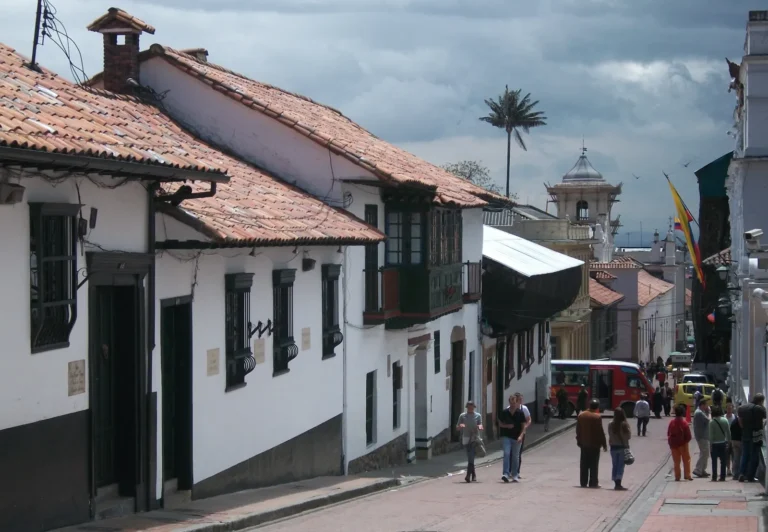 Rua de La Candelaria, em Bogotá, com casas coloniais brancas de telhado de barro e varandas de madeira