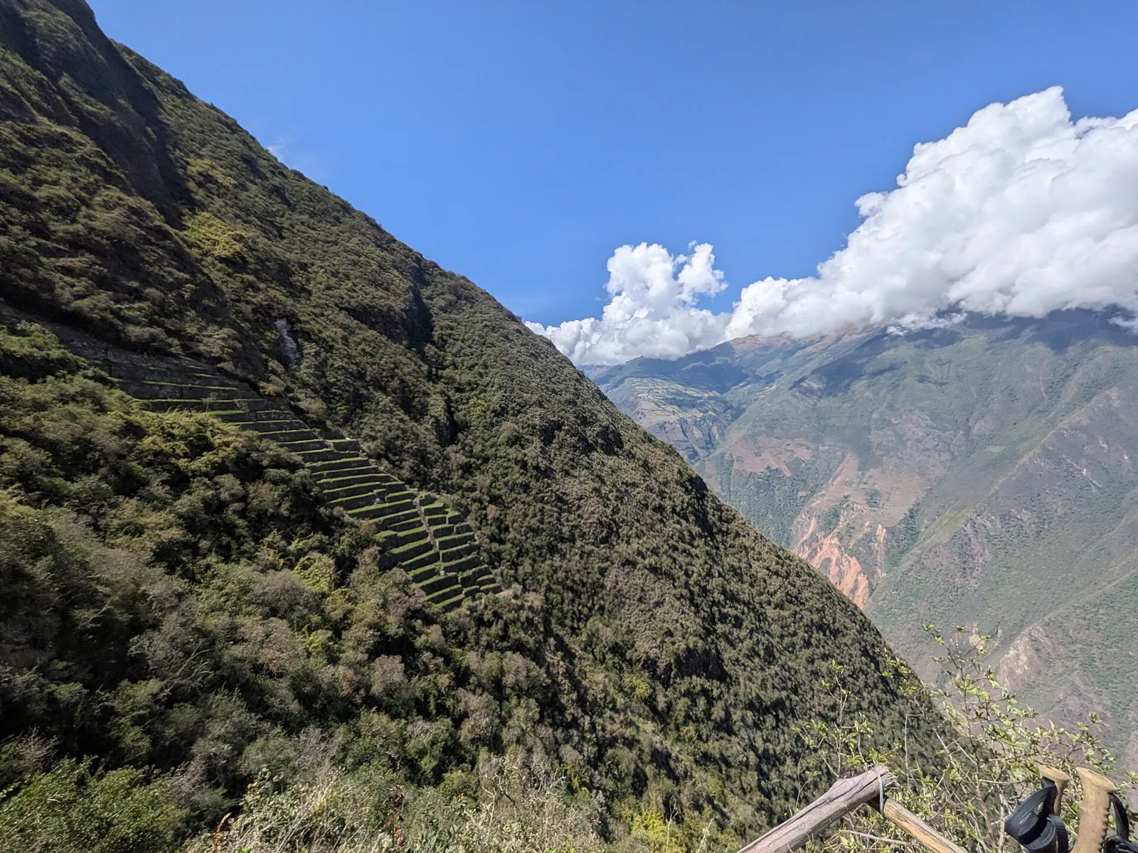Terraços das lhamas de Choquequirao descendo a encosta verde, com montanhas do cânion do Apurímac ao fundo